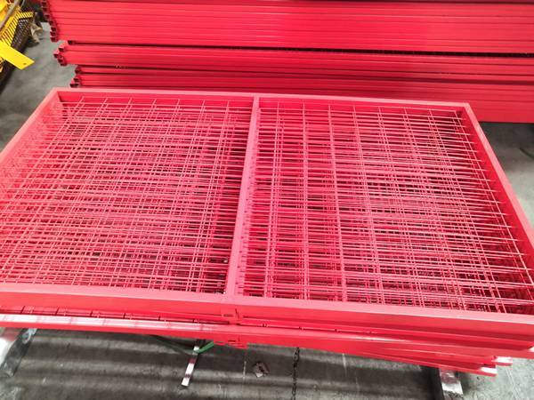 A pile of Canada temporary fences in red are placed on the ground.